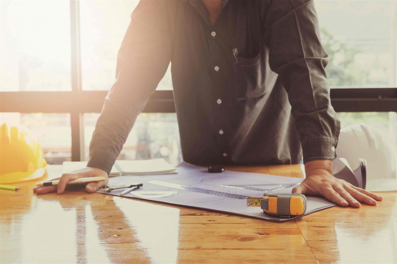 Man looking over plans to renovate a fixer-upper